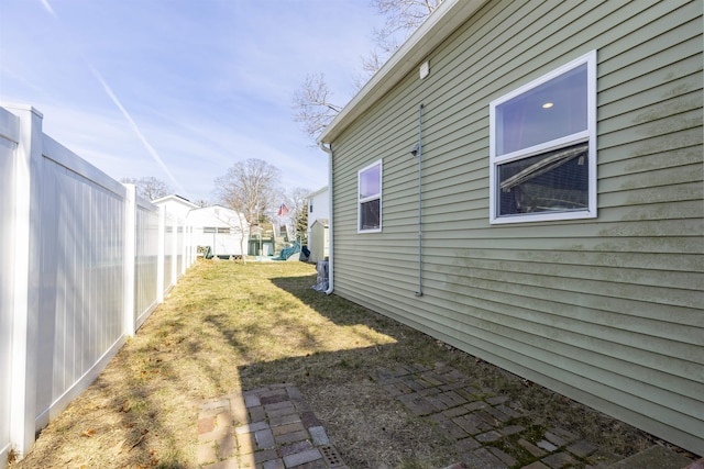 view of home's exterior with a yard and fence