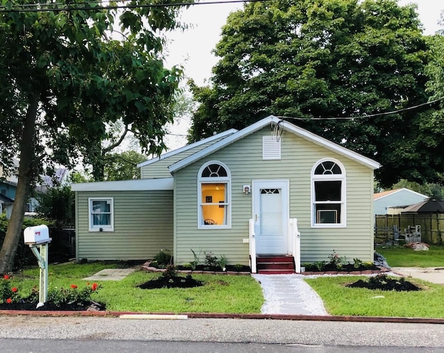 view of front of house with fence and a front lawn