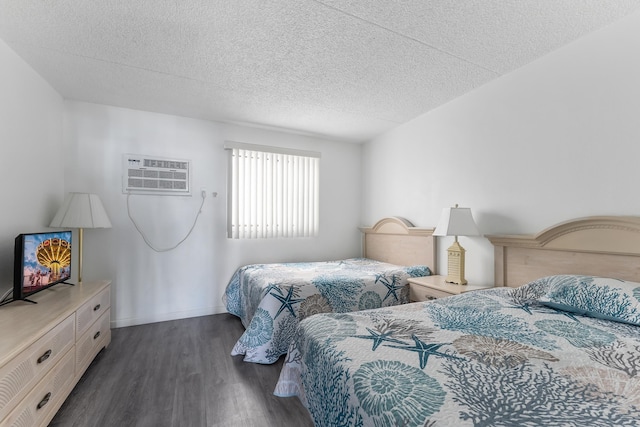 bedroom with dark hardwood / wood-style floors, a wall mounted AC, and a textured ceiling