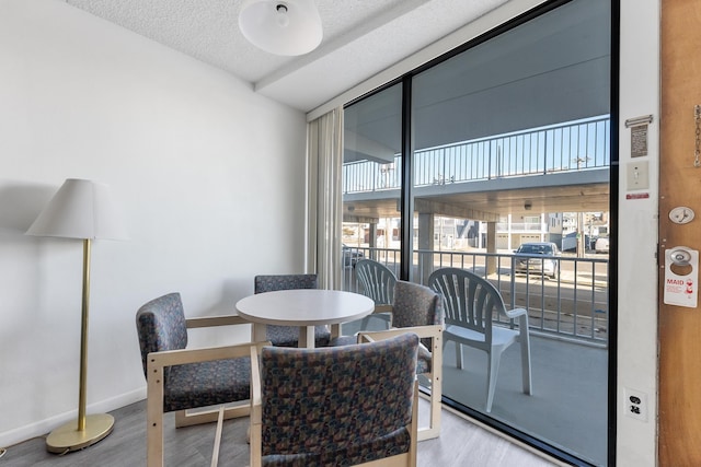 dining area featuring wood-type flooring and a textured ceiling