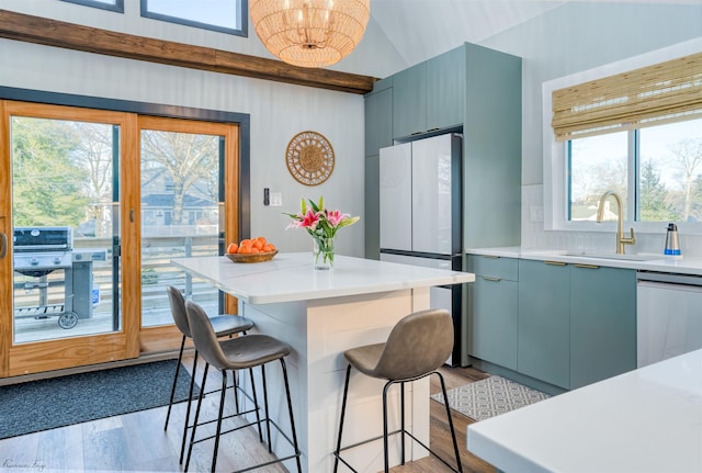 512 Robin Rd, Villas, NJ 08251 - kitchen with a sink, a breakfast bar, dishwashing machine, freestanding refrigerator, and light wood-style flooring