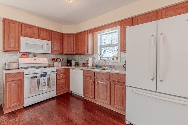 kitchen with backsplash, dark wood finished floors, light countertops, white appliances, and a sink