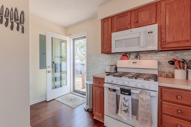 kitchen featuring brown cabinets, electric panel, white appliances, light countertops, and dark wood-style flooring