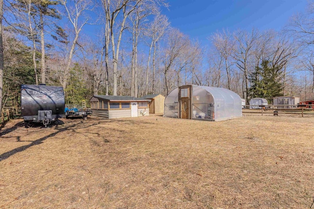 view of yard with an outbuilding, fence, and an exterior structure