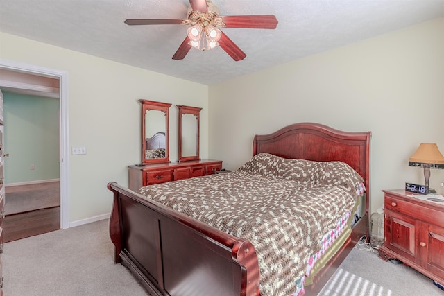 bedroom with light carpet, ceiling fan, a textured ceiling, and baseboards