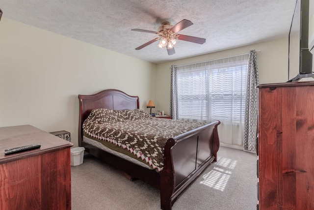 bedroom featuring light colored carpet, a ceiling fan, and a textured ceiling