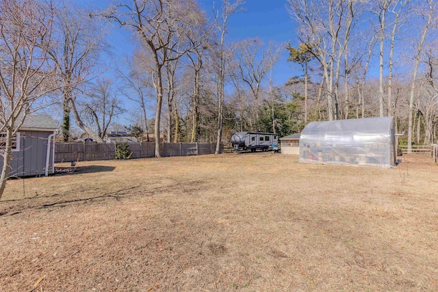 view of yard with an exterior structure, an outdoor structure, and fence