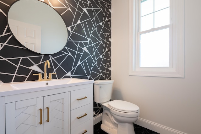 bathroom featuring vanity, toilet, and baseboards