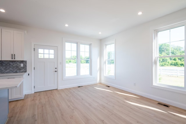 interior space with recessed lighting, light wood-type flooring, visible vents, and baseboards