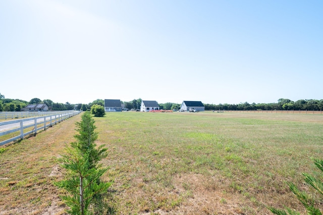 view of yard with a rural view and fence