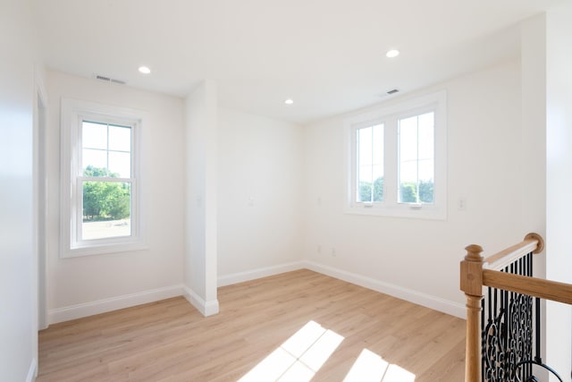 unfurnished room featuring recessed lighting, visible vents, light wood-style flooring, and baseboards