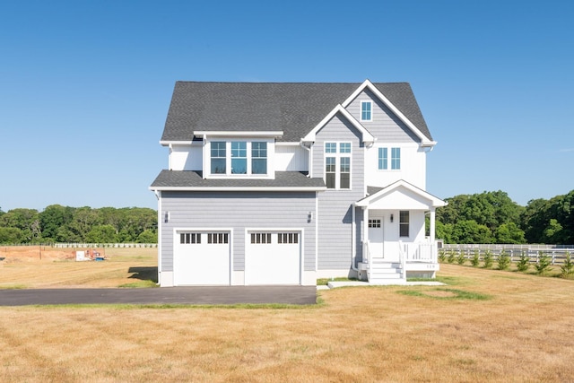 view of front of home featuring a garage, driveway, a shingled roof, fence, and a front lawn