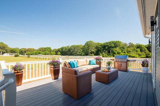 deck with a grill and an outdoor living space