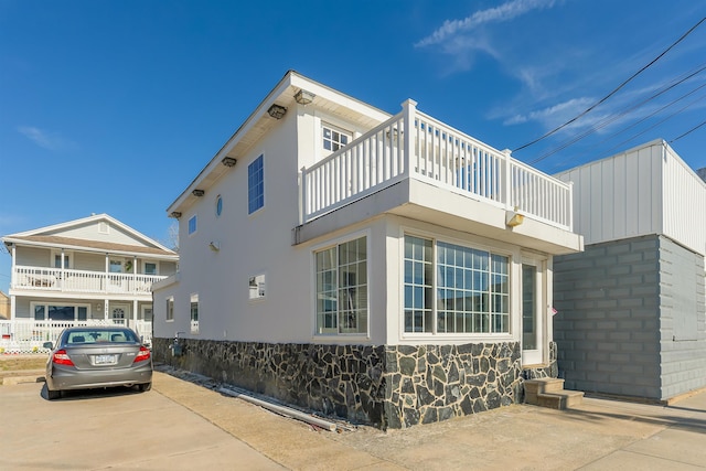 view of side of property with a balcony and stucco siding