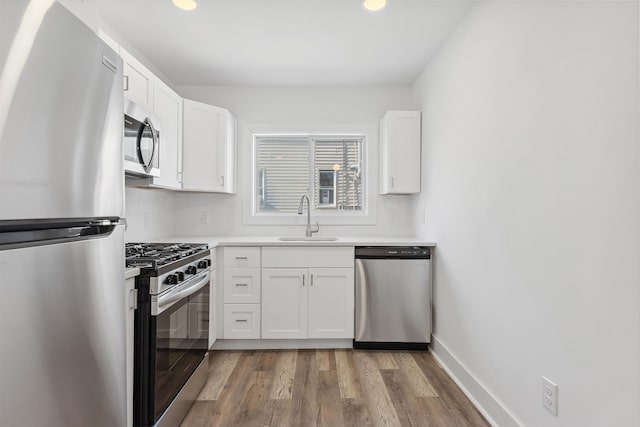 kitchen featuring stainless steel appliances, a sink, white cabinets, light countertops, and backsplash