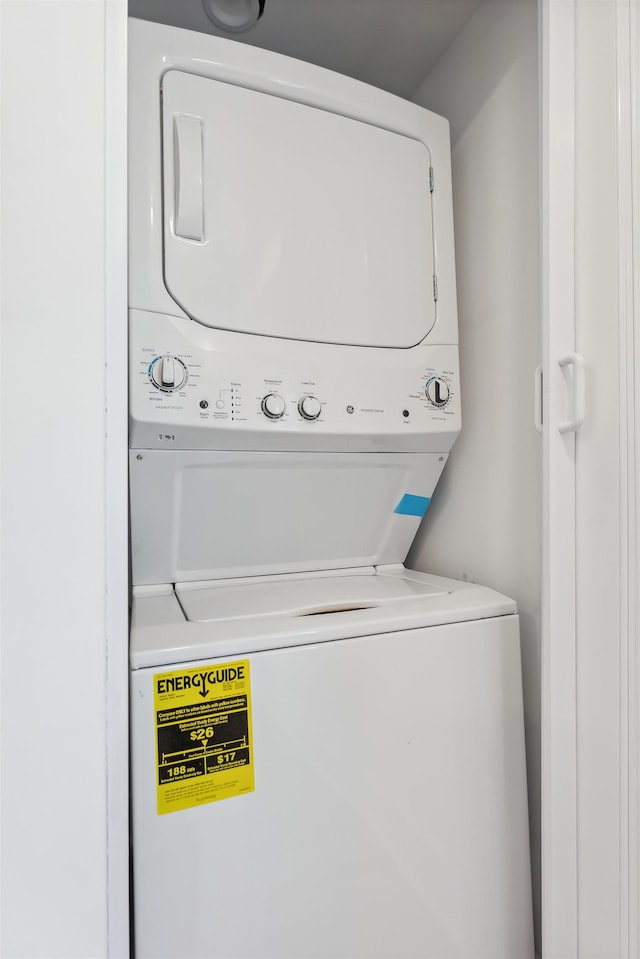 clothes washing area with stacked washer and dryer and laundry area