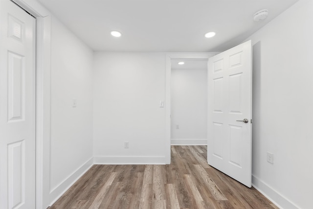 empty room with recessed lighting, baseboards, and wood finished floors