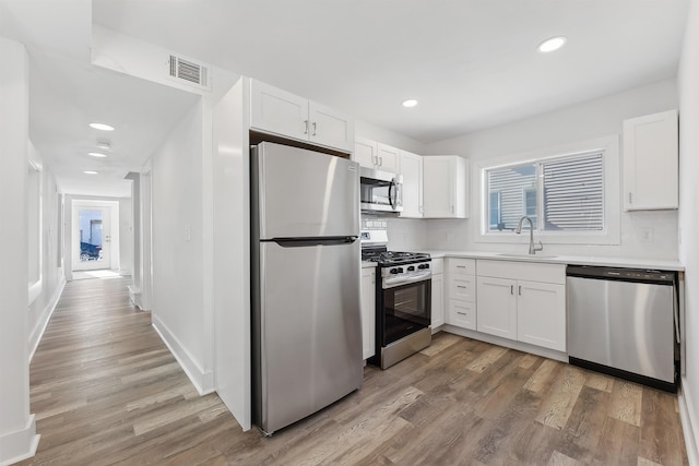 kitchen featuring white cabinetry, appliances with stainless steel finishes, and a sink