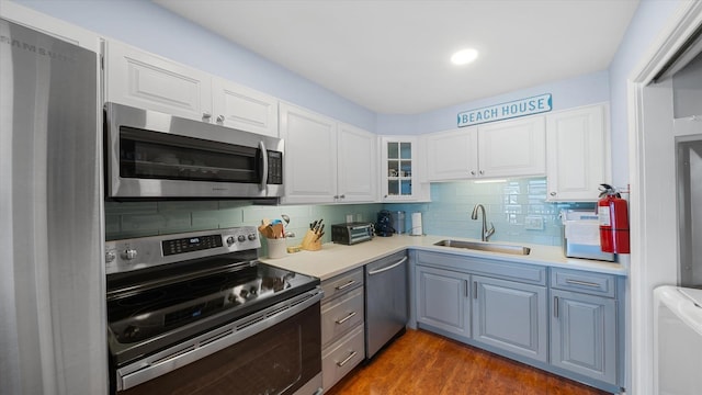 351 96th St Unit 209, Stone Harbor, NJ 08247 - kitchen with appliances with stainless steel finishes, a sink, backsplash, and white cabinets