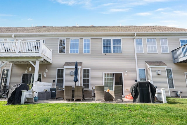 back of property with a lawn and a patio area