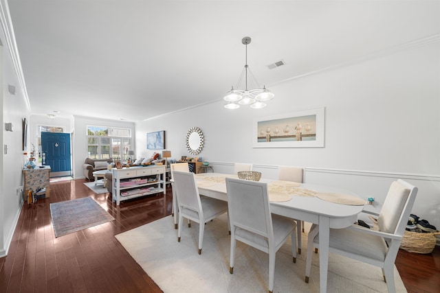 dining space featuring hardwood / wood-style floors, a notable chandelier, and ornamental molding