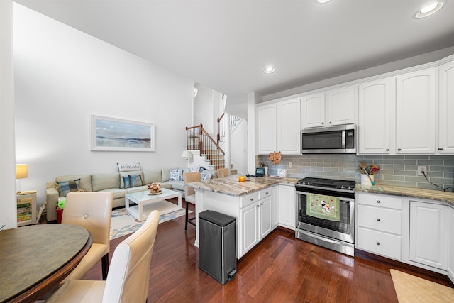 kitchen with dark stone countertops, white cabinetry, and stainless steel appliances