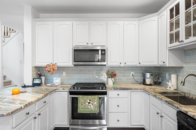 kitchen featuring white cabinets, appliances with stainless steel finishes, and tasteful backsplash