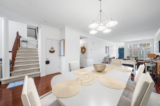 dining space featuring wood-type flooring, crown molding, and a notable chandelier