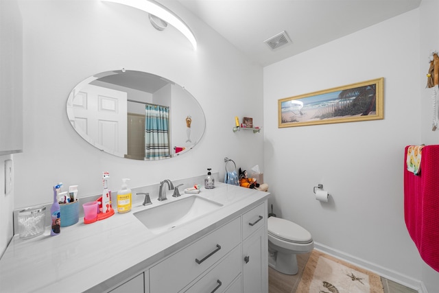 bathroom featuring walk in shower, tile patterned floors, vanity, and toilet