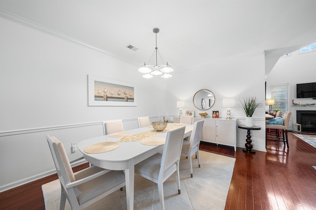 dining room featuring crown molding, dark hardwood / wood-style flooring, and a chandelier