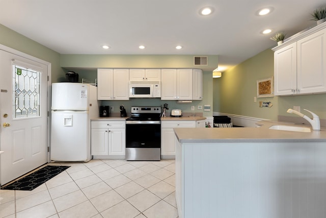 kitchen with white appliances, light tile patterned floors, sink, and white cabinets