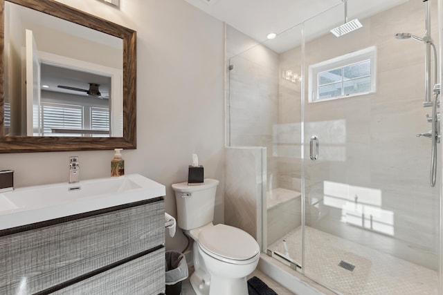 bathroom with vanity, ceiling fan, toilet, and a shower with shower door