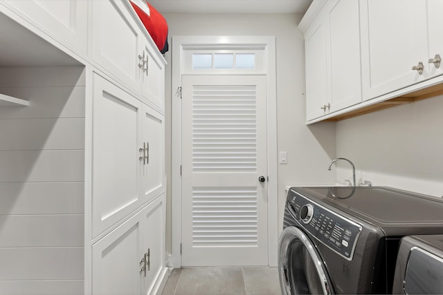 laundry area with cabinets, independent washer and dryer, and light tile patterned floors