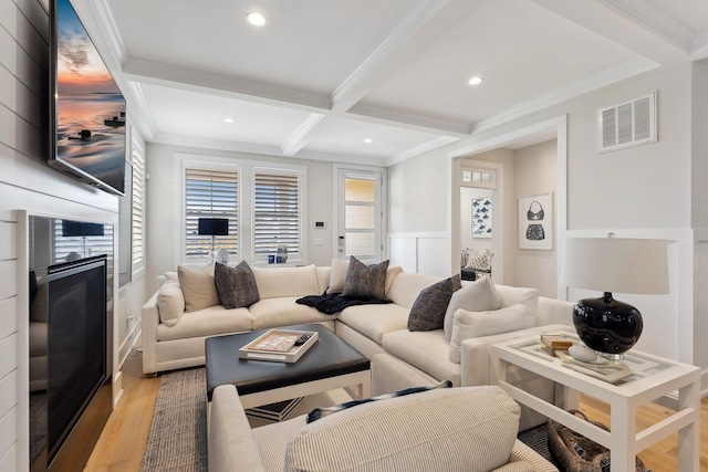 living room featuring light hardwood / wood-style flooring, beam ceiling, crown molding, and coffered ceiling