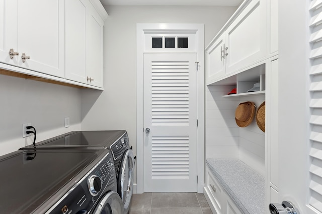 laundry room with washer and clothes dryer, cabinets, and light tile patterned floors