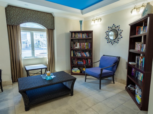 living area featuring light tile patterned floors, ornamental molding, and a raised ceiling
