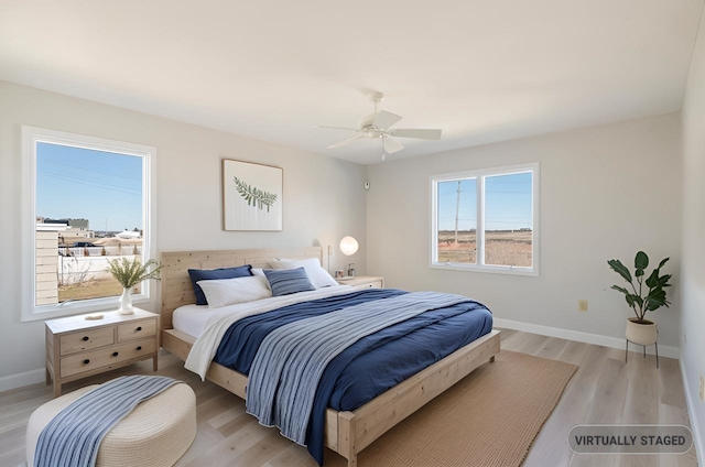 bedroom with a ceiling fan, baseboards, and light wood finished floors