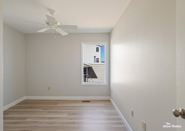 empty room with visible vents, ceiling fan, baseboards, and light wood-style floors
