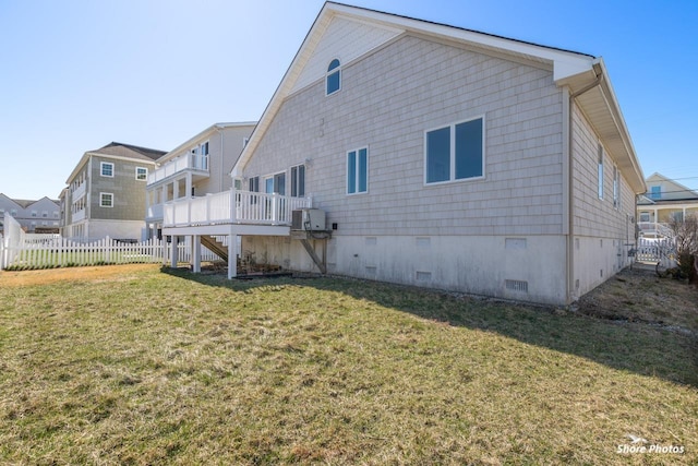 rear view of house with fence, stairway, a wooden deck, a lawn, and crawl space