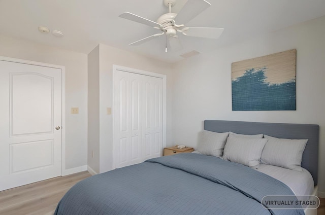 bedroom with a closet, baseboards, light wood-type flooring, and ceiling fan