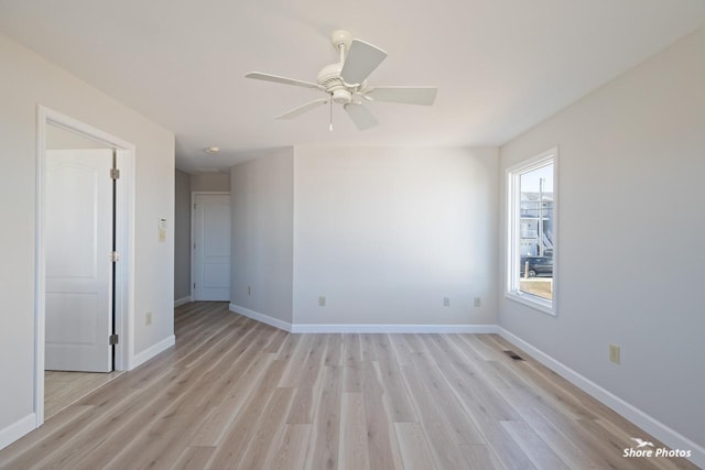 empty room with baseboards and light wood-style floors