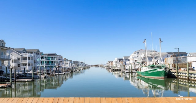 view of dock with a residential view and a water view