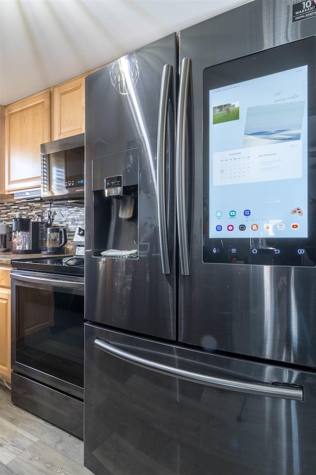 kitchen featuring appliances with stainless steel finishes, light hardwood / wood-style flooring, backsplash, and light brown cabinets