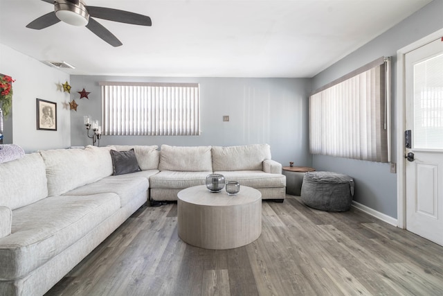 living room featuring a healthy amount of sunlight, ceiling fan, and wood-type flooring