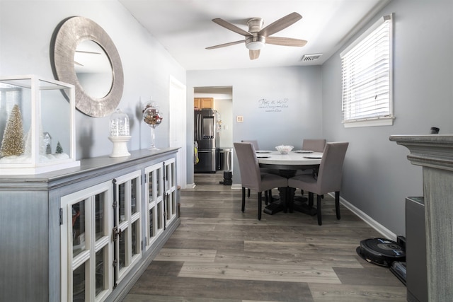 dining room with ceiling fan and dark wood-type flooring