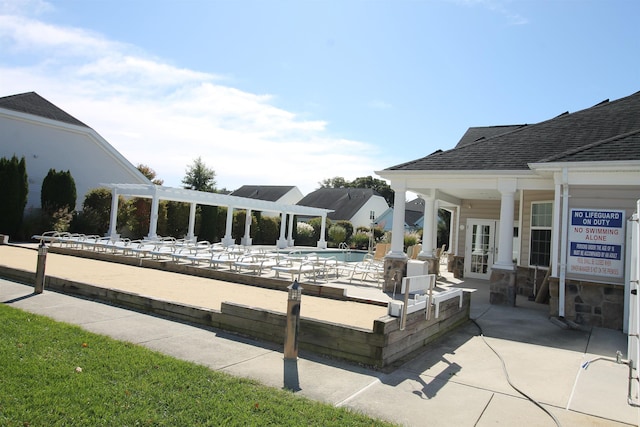 community pool with a patio area, a pergola, and french doors