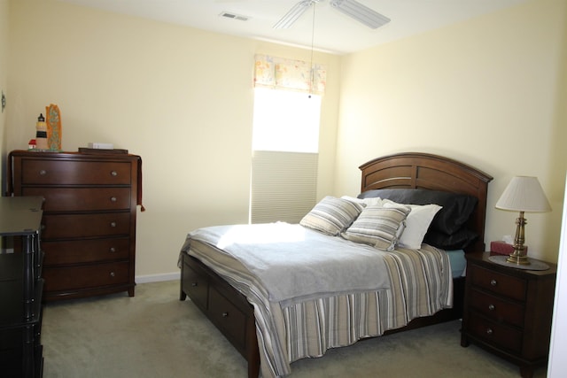 bedroom featuring a ceiling fan, visible vents, light carpet, and baseboards