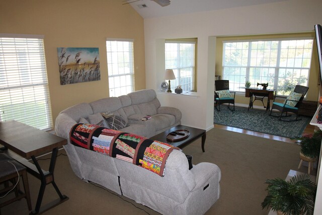 living room with a high end fireplace, wood-type flooring, and a wealth of natural light