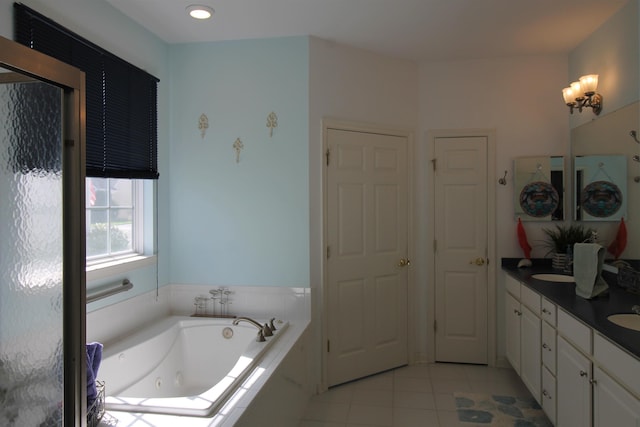 bathroom featuring vanity, tile patterned flooring, and a relaxing tiled tub