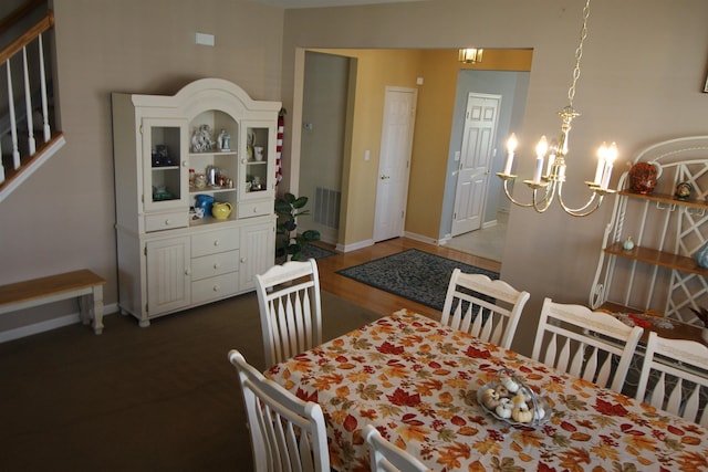 dining room with visible vents, a notable chandelier, baseboards, and stairs